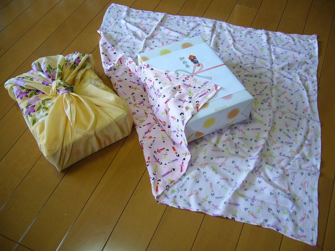 Två presenter vackert inslagna med den japanska furoshiki-tekniken, en hållbar och elegant metod.
